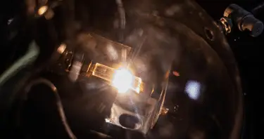 A helmet illuminated by a beam of light, casting shadows in a dark environment.