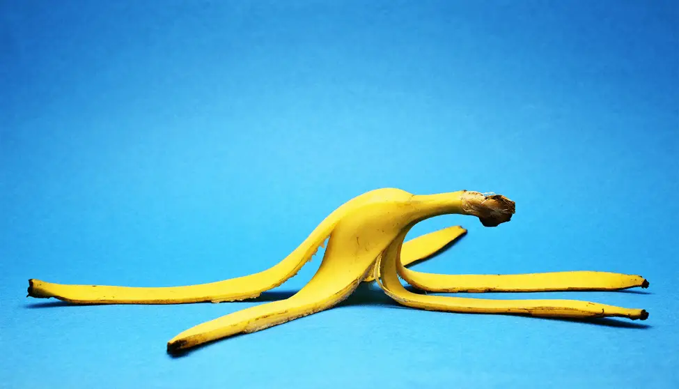 A ripe banana placed on a vibrant blue background, highlighting its yellow color and smooth texture.