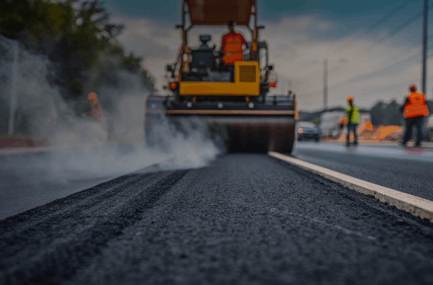 A man operates a bulldozer on a construction site, working on road maintenance and improvement.